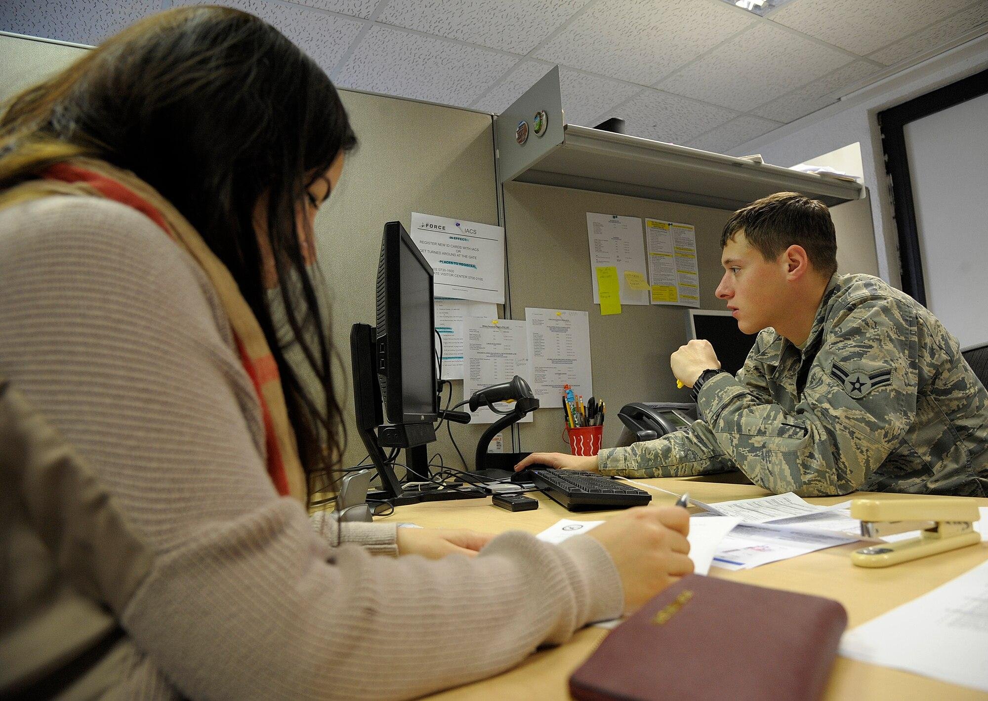 Personnel assistant processing Common Access Card and DEERS enrollment transactions at a customer service workstation inside an Air Combat Command Military Personnel Flight